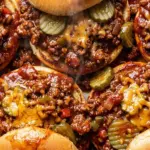 Easy sloppy joes recipe sandwiches with cheesy beef and pickles on soft toasted buns.